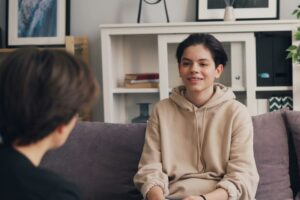 Young client sitting in a therapy session, representing progress and emotional shifts supported by Neurofeedback