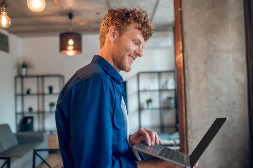 Man working on laptop at home representing improved clarity and emotional stability using NeurOptimal®