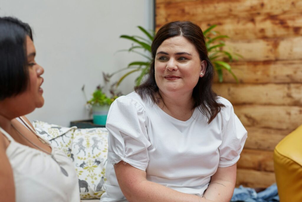 NDIS support worker sitting with a client, showing calm and attentive engagement during a conversation