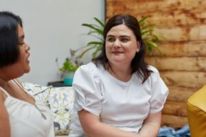 NDIS support worker sitting with a client, showing calm and attentive engagement during a conversation