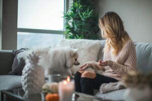 Young woman relaxing at home with her dog representing calm mood and emotional balance using NeurOptimal®