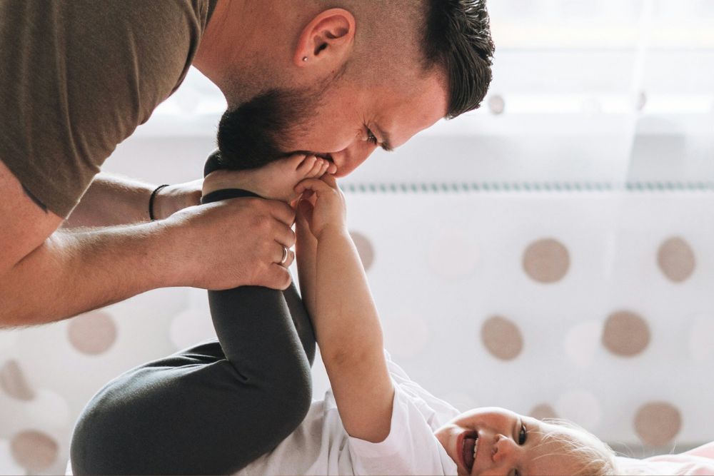 Father playing with young child at home representing connection, emotional wellbeing, and support for DVA clients and veteran families.
