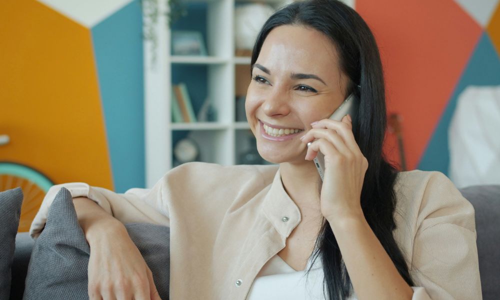 Woman speaking on the phone, representing personal support for NeurOptimal neurofeedback rental clients