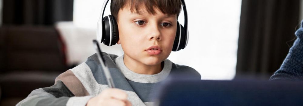 Child studying with headphones, representing focus, learning and better school performance