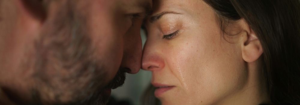 Couple supporting each other through an emotional moment during their fertility journey