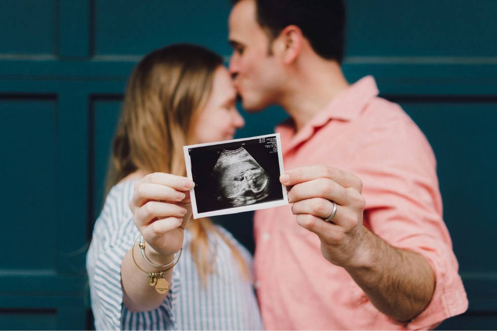 Couple holding an ultrasound image, representing fertility wellbeing and neurofeedback support