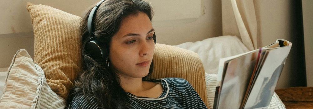 Woman relaxing at home with headphones during her fertility journey