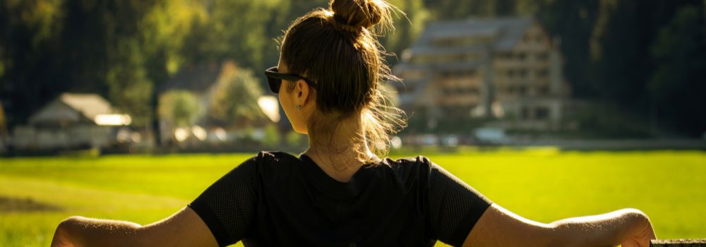 Woman looking across an open landscape, representing greater clarity, perspective and personal growth