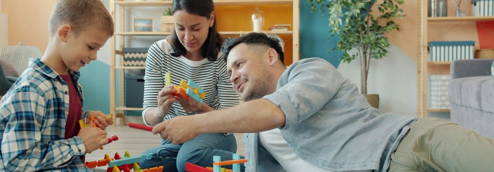 Child playing with his parents at home, representing stronger connection and engagement for NDIS participants