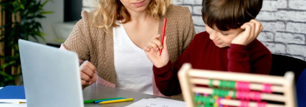 Child learning with an adult at home, representing building skills and setting NDIS participants up for future success
