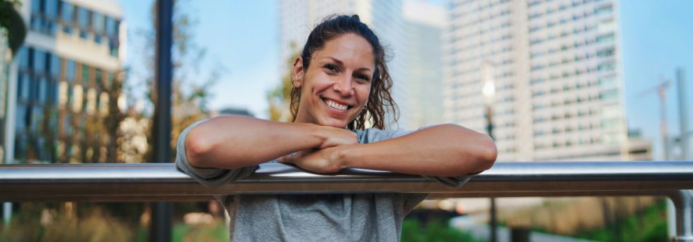 Woman smiling outdoors, representing feeling refreshed and more like yourself again