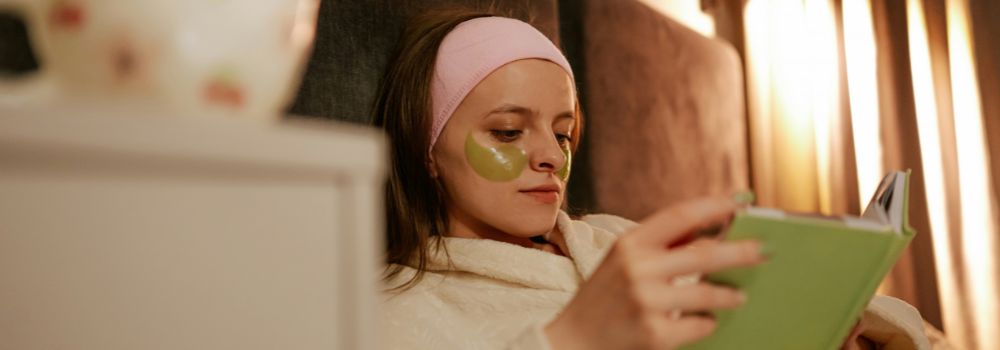 Woman relaxing in bed with a book, representing feeling more comfortable about bedtime