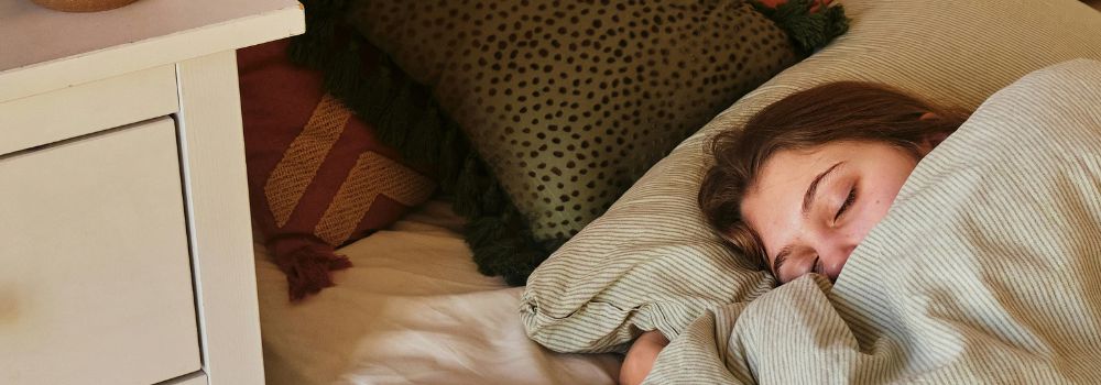 Student sleeping comfortably in bed, representing better sleep for study and learning