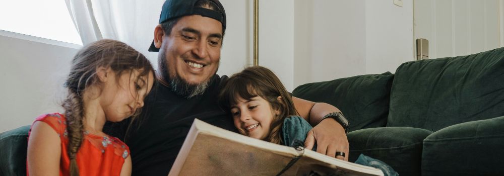 Father relaxing with his children at home, representing less anger and calmer emotional responses after trauma