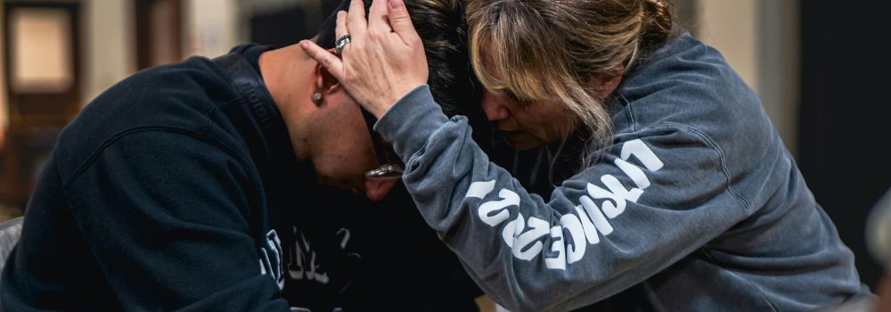 Person being comforted during an emotional moment, representing processing difficult emotions after trauma