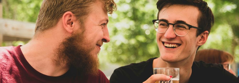Veteran laughing with a friend outdoors, representing moving forward, connection and enjoying everyday life