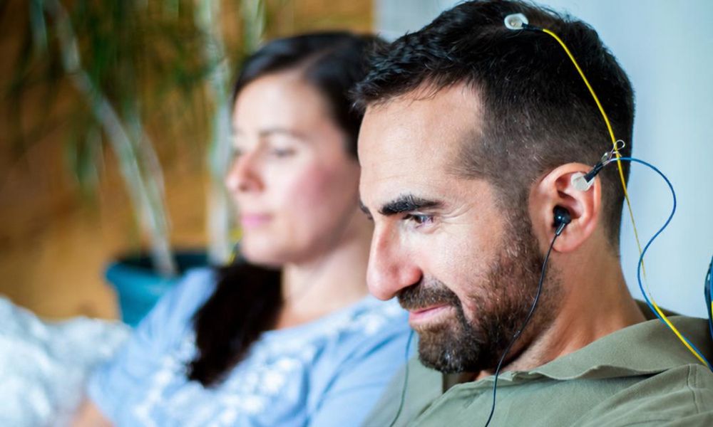 Man wearing NeurOptimal neurofeedback sensors on his scalp and ears during a session
