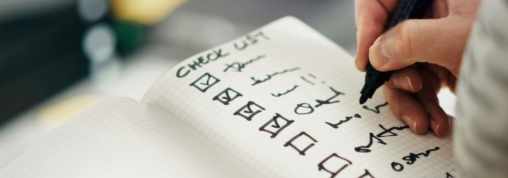 Person ticking off tasks on a checklist, representing reduced procrastination, improved focus and productivity