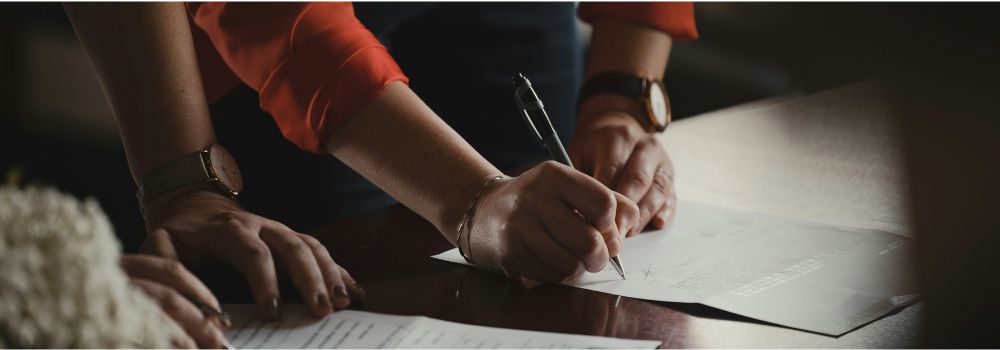 Business professionals reviewing and signing documents, representing the ability to identify new opportunities and make informed decisions